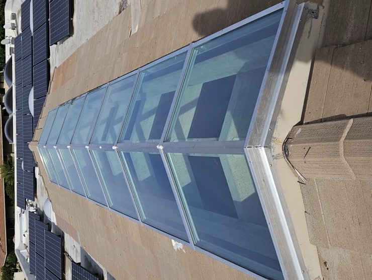A 30ft x 8ft multi-pane architectural glass ridge skylight installed on a commercial roof